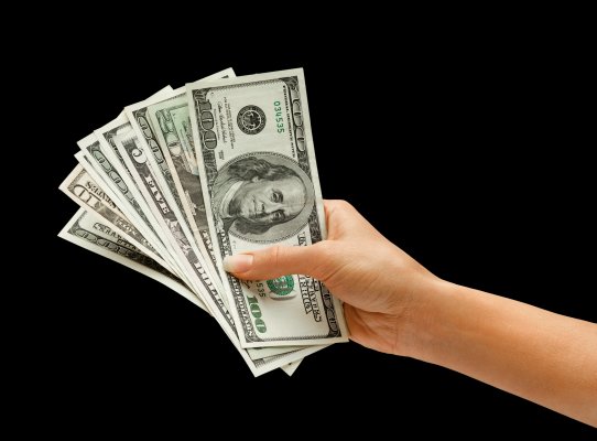 hand holding dollar bills black background payday loans